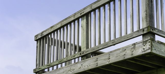 A wooden deck with a railing set